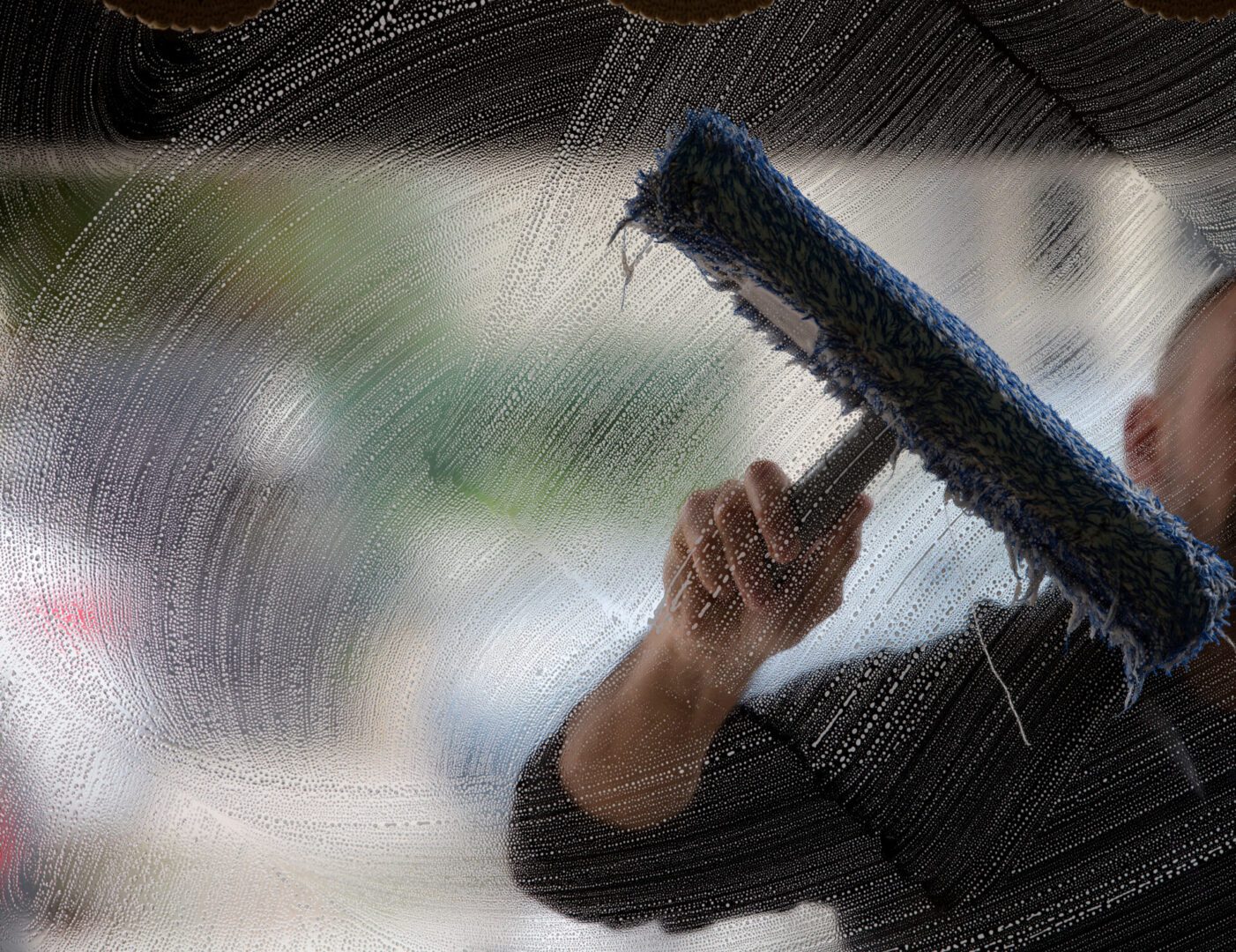 a soapy window with a squeegee cleaning the glass