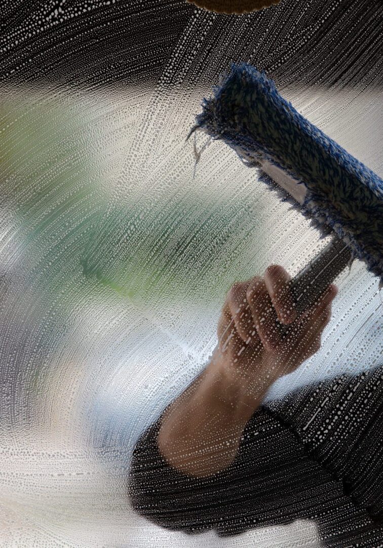 a soapy window with a squeegee cleaning the glass